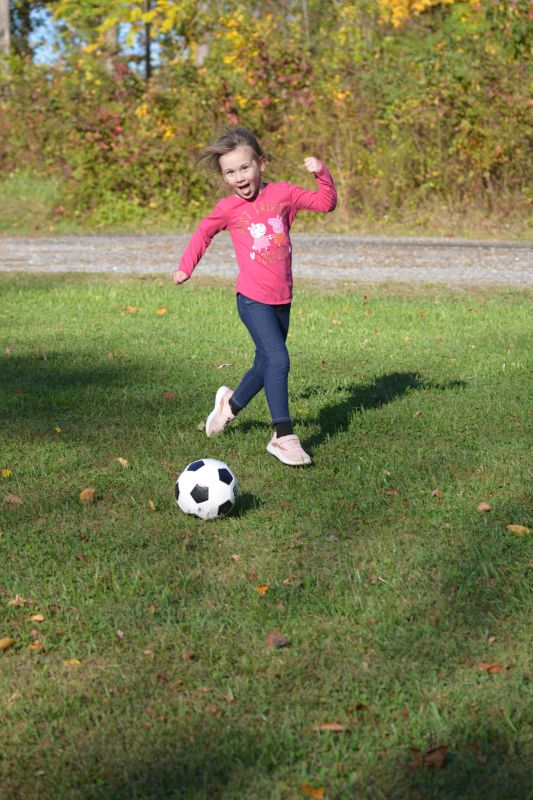 Naomi Kicking the Soccer Ball Around the Yard